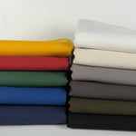Stack of folded KBM cotton duck canvas in ten solid colors