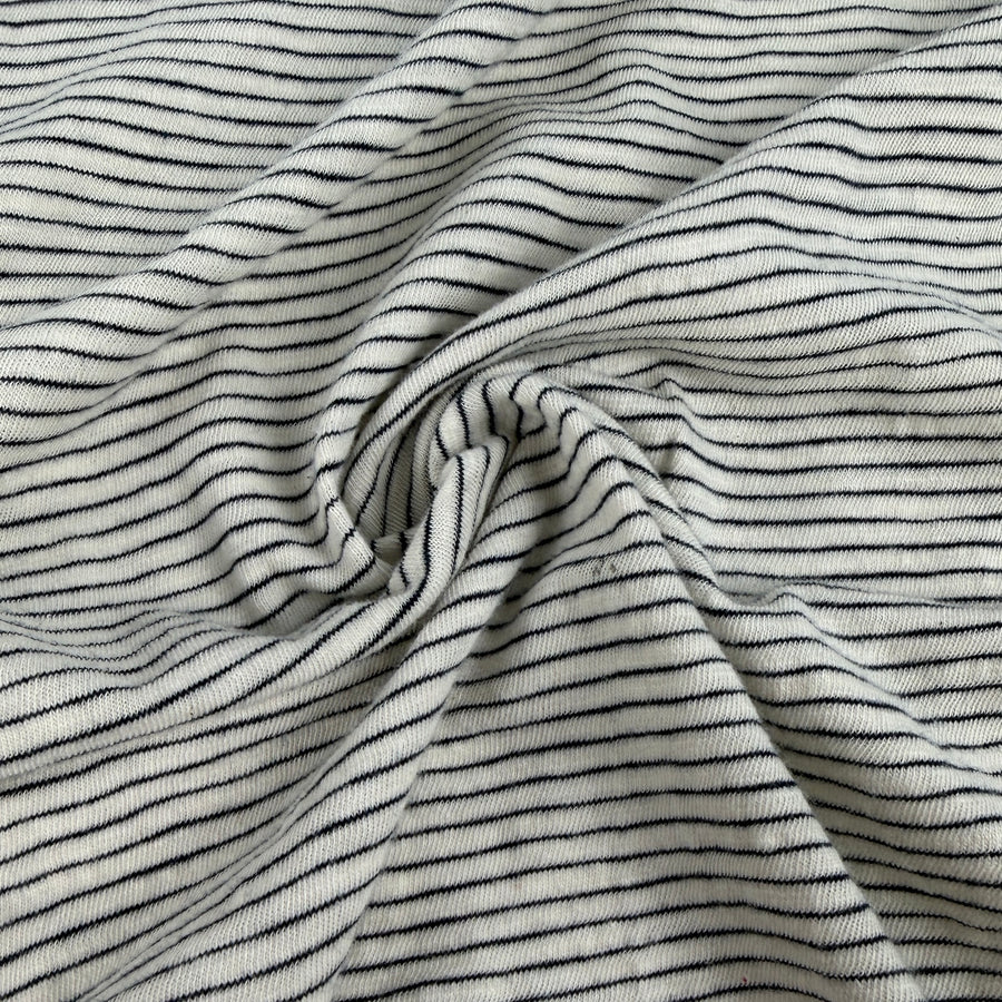 Cotton slub jersey with fine navy pinstripes on a natural ground, swirled
